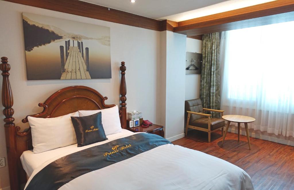 a hotel room with a bed and a chair at Prince Hotel in Goseong