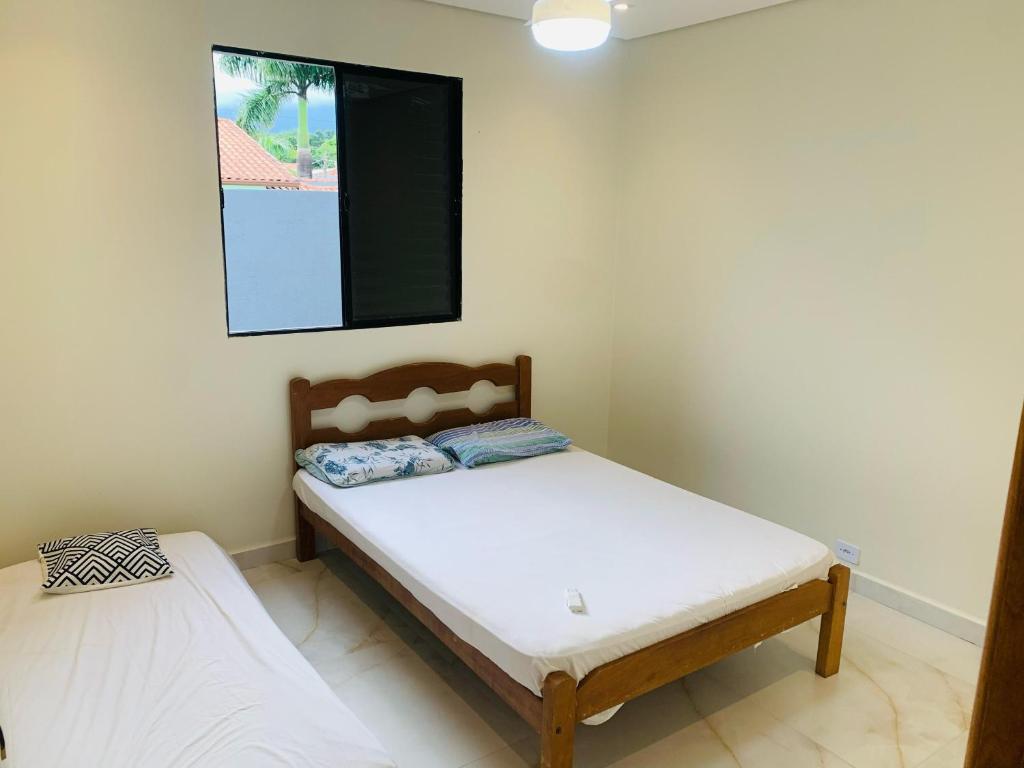 una camera da letto con due letti e un quadro sul muro di Casa com Piscina no litoral norte a Bertioga