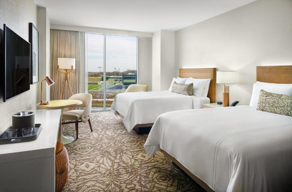 Una habitación de hotel con dos camas y un televisor. en Omni Viking Lakes, en Eagan