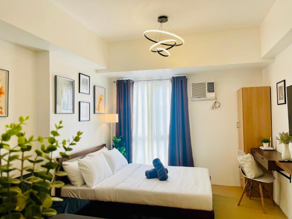 ein Schlafzimmer mit einem Bett mit einem blauen Teddybär darauf in der Unterkunft Peaceful Studio Unit at Centrio Tower beside Ayala Mall in Cagayan de Oro