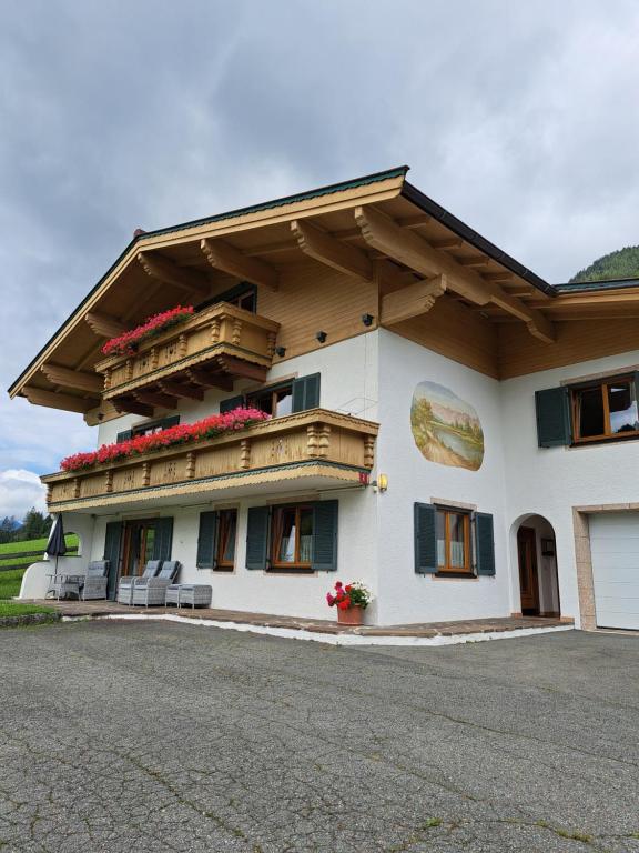 budynek z balkonem pokrytym kwiatami w obiekcie Ferienwohnungen am Lift 2 w mieście Sankt Jakob in Haus