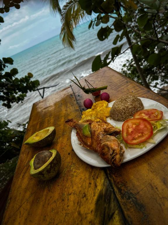 a plate of food on a table next to the beach at Los Achiotes Hostal - Palomino in Palomino