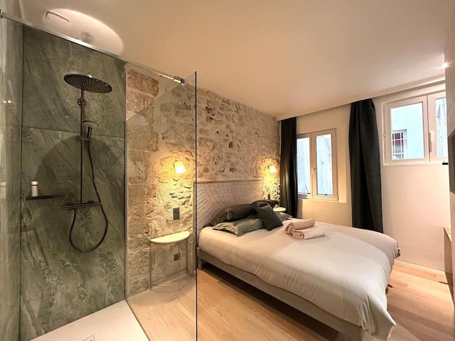 une chambre avec un lit et une douche en verre dans l'établissement Louvre -Notre Dame 2BD, 2BATH AC, à Paris