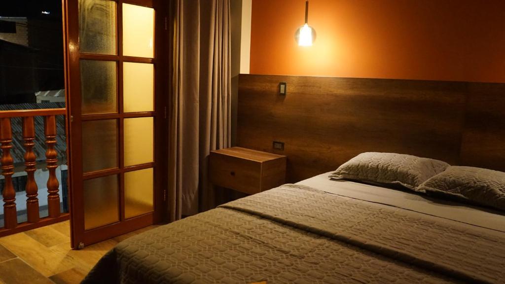 Un dormitorio con una cama con cabecero de madera. en Ukumari Hotel, en Chachapoyas