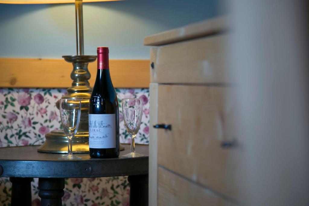 - une bouteille de vin assise sur une table avec deux verres dans l'établissement Duch Tatr, à Zakopane