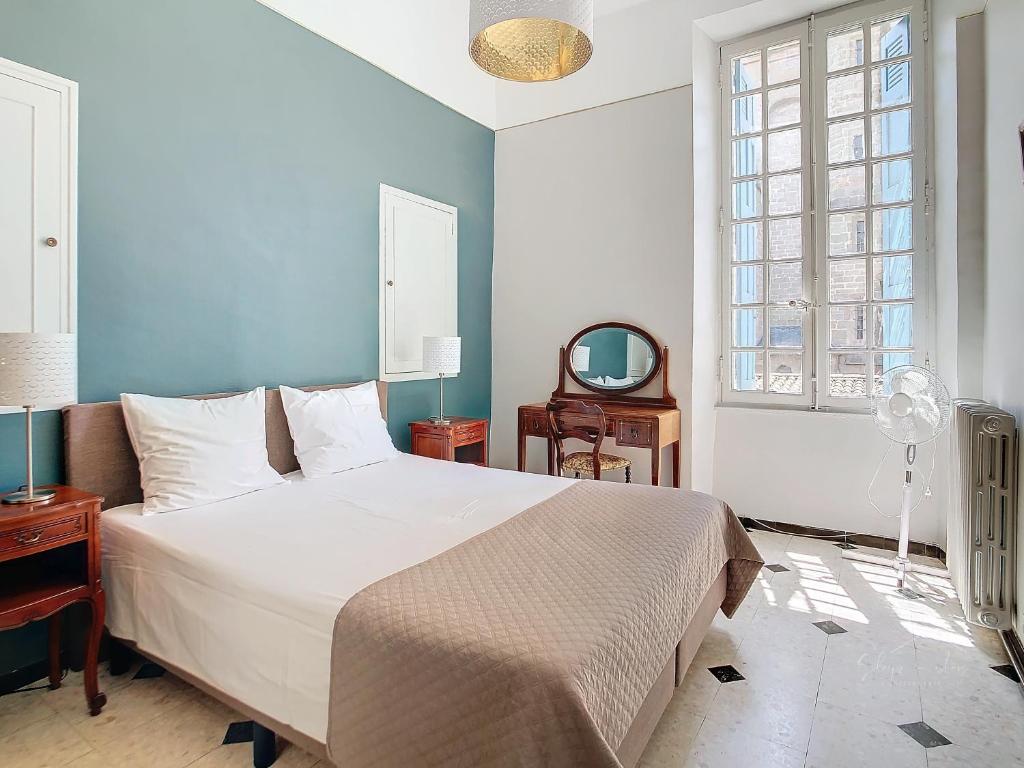 Un dormitorio con una gran cama blanca y una ventana. en Apartment La Terasse, en Carcassonne