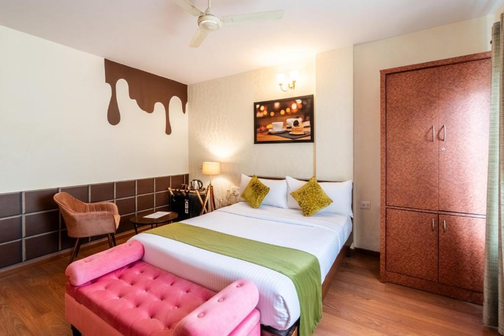 una camera con un letto e un divano rosa di Chocolat house a Bangalore