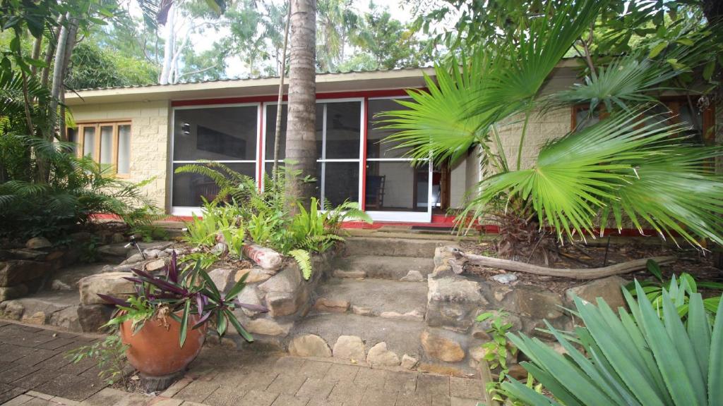 a house with a bunch of plants in front of it at Moana Cottage, Stroll To Horseshoe Bay Beachfront in Horseshoe Bay