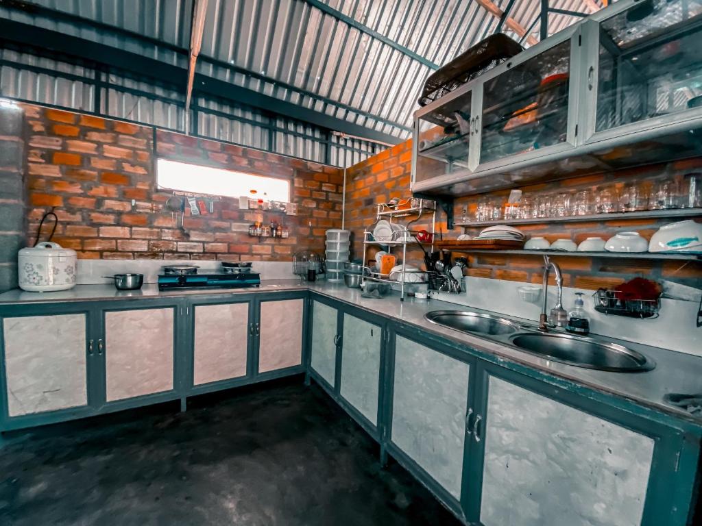 una cucina con lavandino e muro di mattoni di Gem’s House a Mui Ne