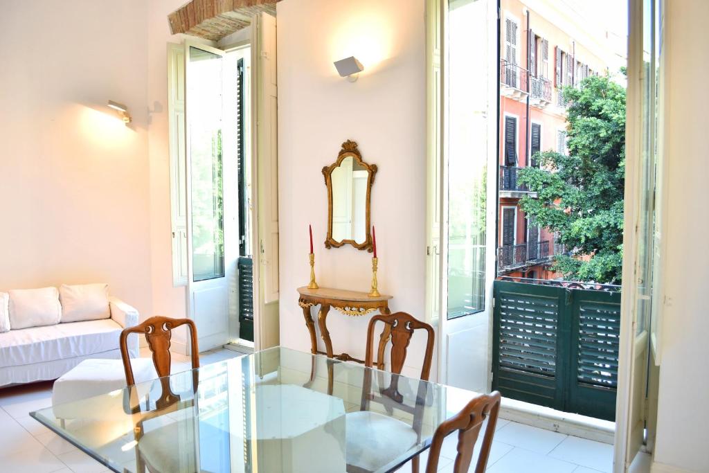 a dining room with a glass table and two chairs at Sinclair , loft in center with original romantic fresco in Cagliari