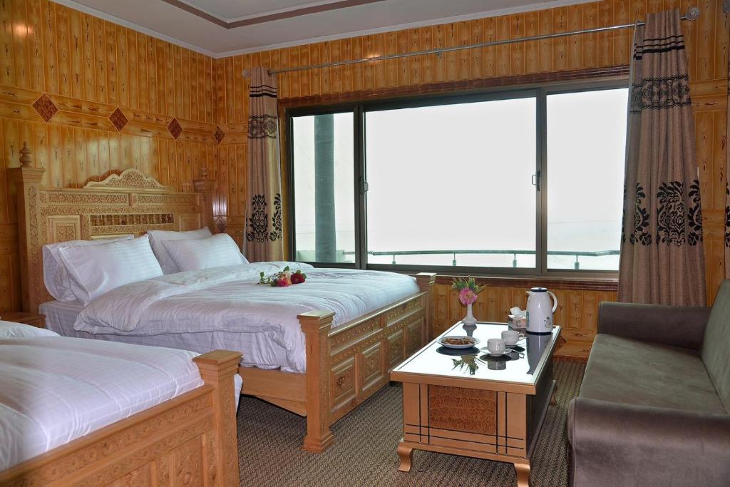 a hotel room with two beds and a window at Hotel Blangsa Indus View in Skardu