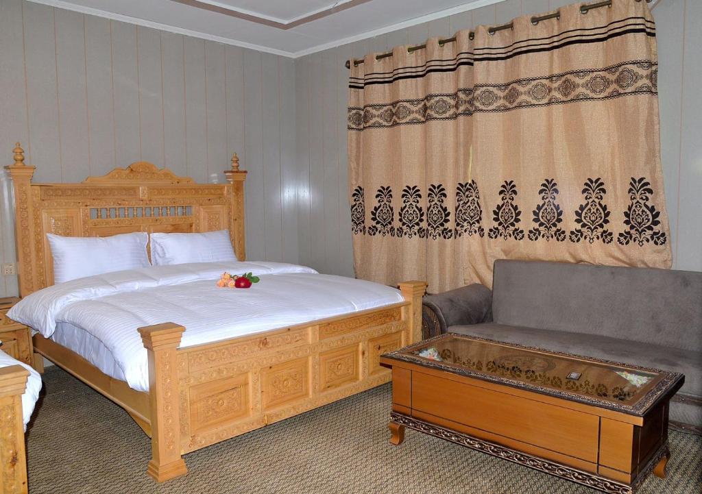 a bedroom with a bed and a couch in it at Hotel Blangsa Indus View in Skardu