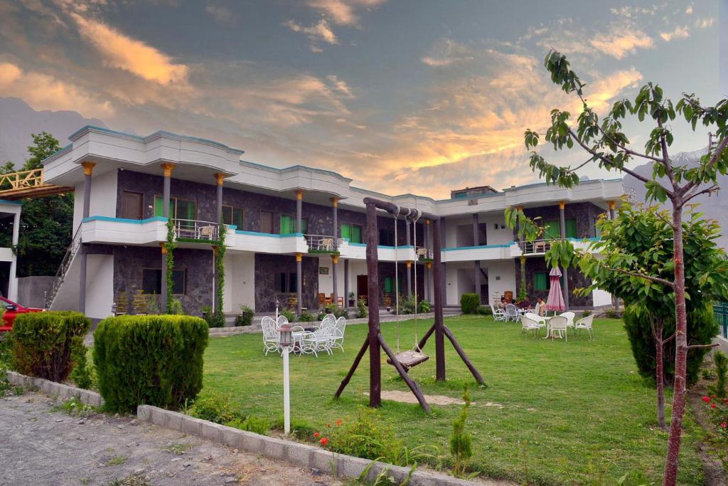 a building with chairs and tables in a yard at Hotel Blangsa Indus View in Skardu