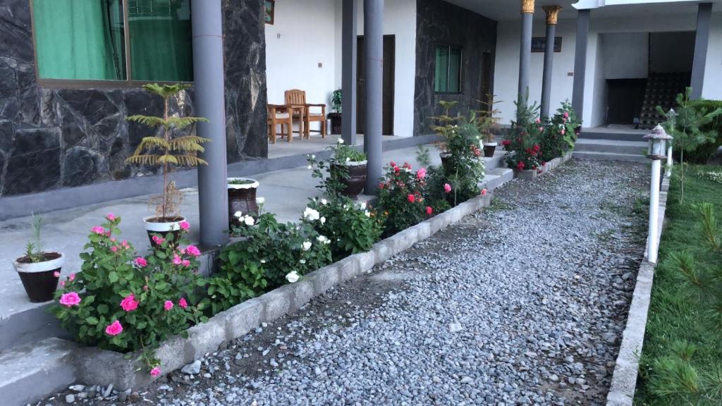 a row of flowers in front of a house at Hotel Blangsa Indus View in Skardu