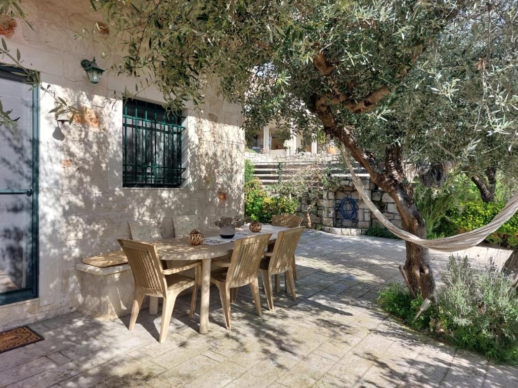 un tavolo e sedie in un patio con un albero di Cottage Meraki a Káto Kalésia