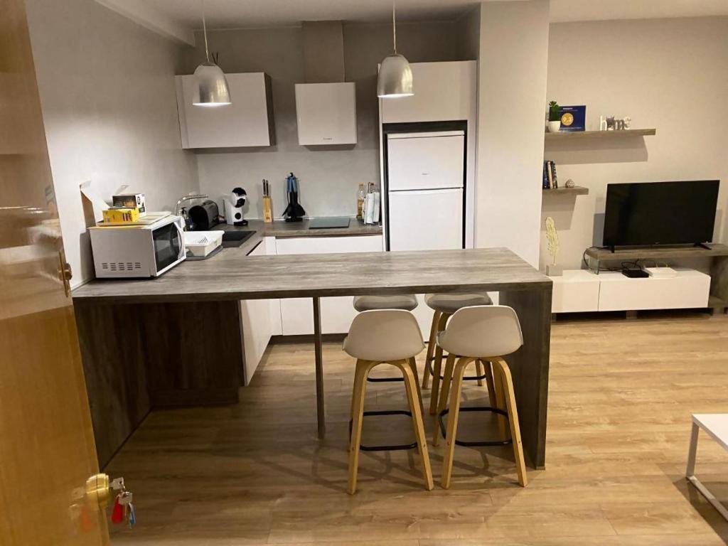 a kitchen with a counter with four stools around it at ENCANTO CUENCA Balcones De La Historia in Cuenca