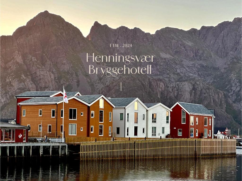 a row of houses in front of a mountain at Henningsv&aelig;r Bryggehotell - by Classic Norway Hotels in Henningsv&aelig;r