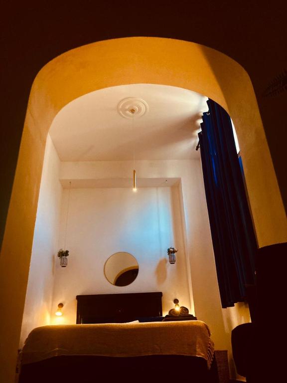 a room with an arch with a bed and a mirror at Domus Mylae in Milazzo