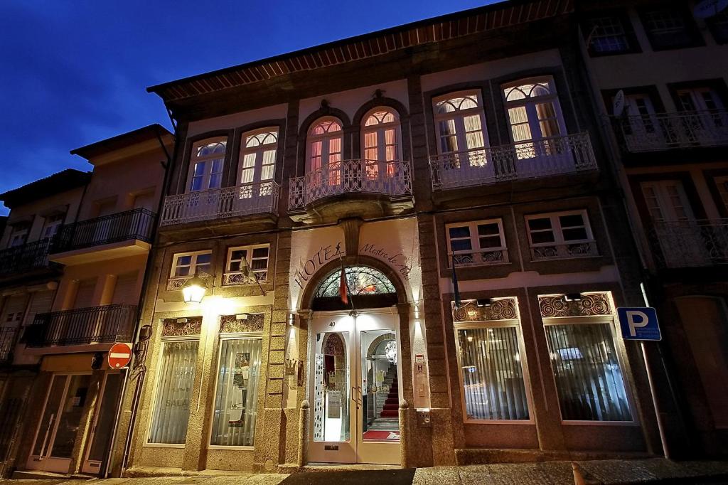 a building with a store front at night at Hotel Mestre de Avis in Guimarães