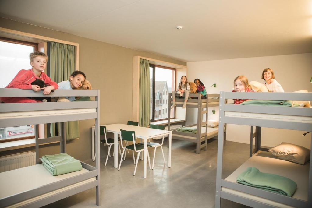 a group of children in bunk beds in a room at Hostel Groeninghe in Kortrijk