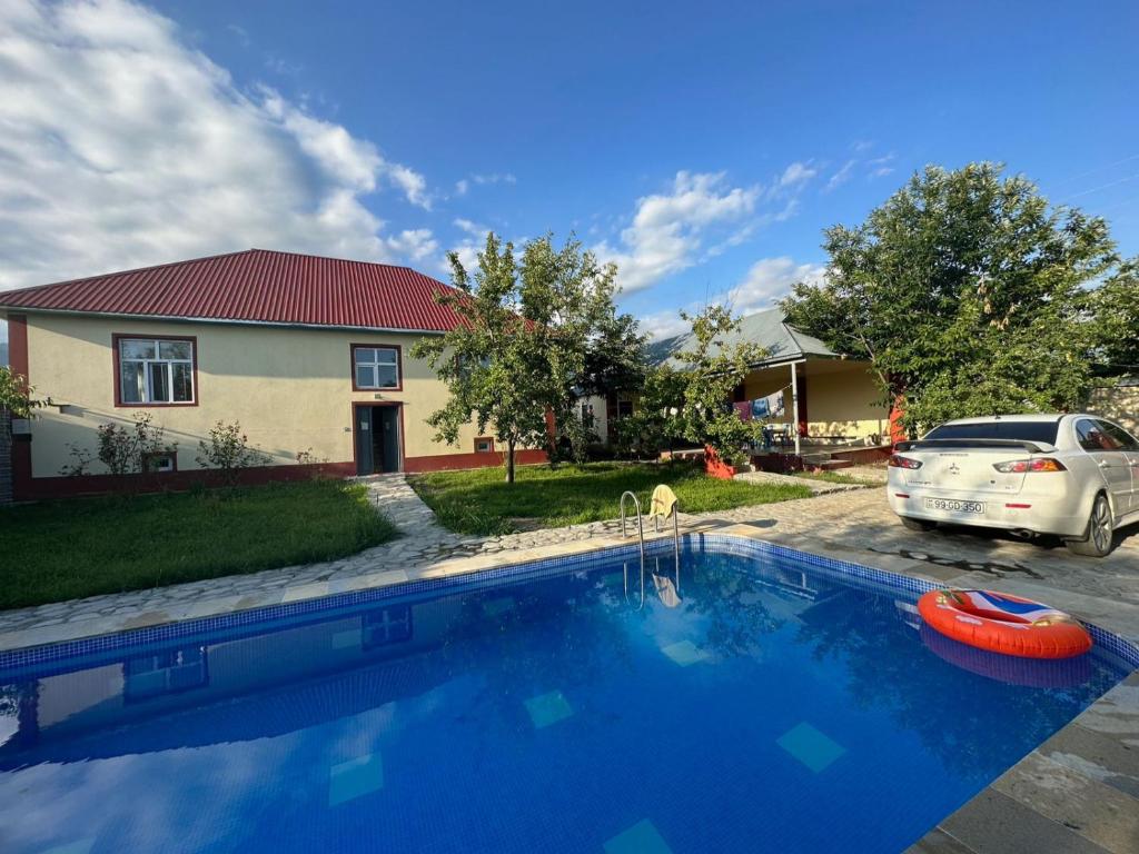 a house with a swimming pool in front of a car at Vandam Luminous Villa in Gabala