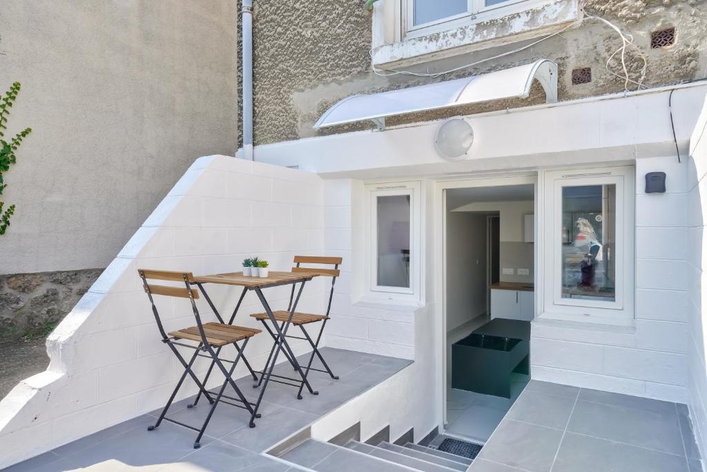 Elle comprend une petite terrasse avec une table et des chaises. dans l'établissement Cozy Moderne - Studio rénové 4p, à Bois-dʼArcy