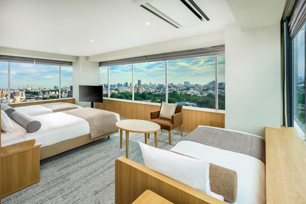 a hotel room with two beds and a view of the city at ART HOTEL Nippori Lungwood in Tokyo