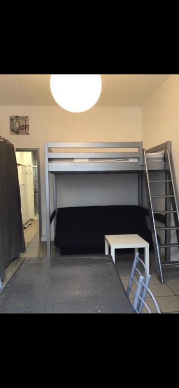 une chambre avec deux lits superposés et une table dans l'établissement Studio 11 Malo les bains proche plage, à Dunkerque