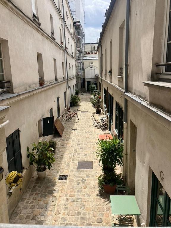 une allée vide avec des plantes en pot dans un bâtiment dans l'établissement Appartement 9e, à Paris