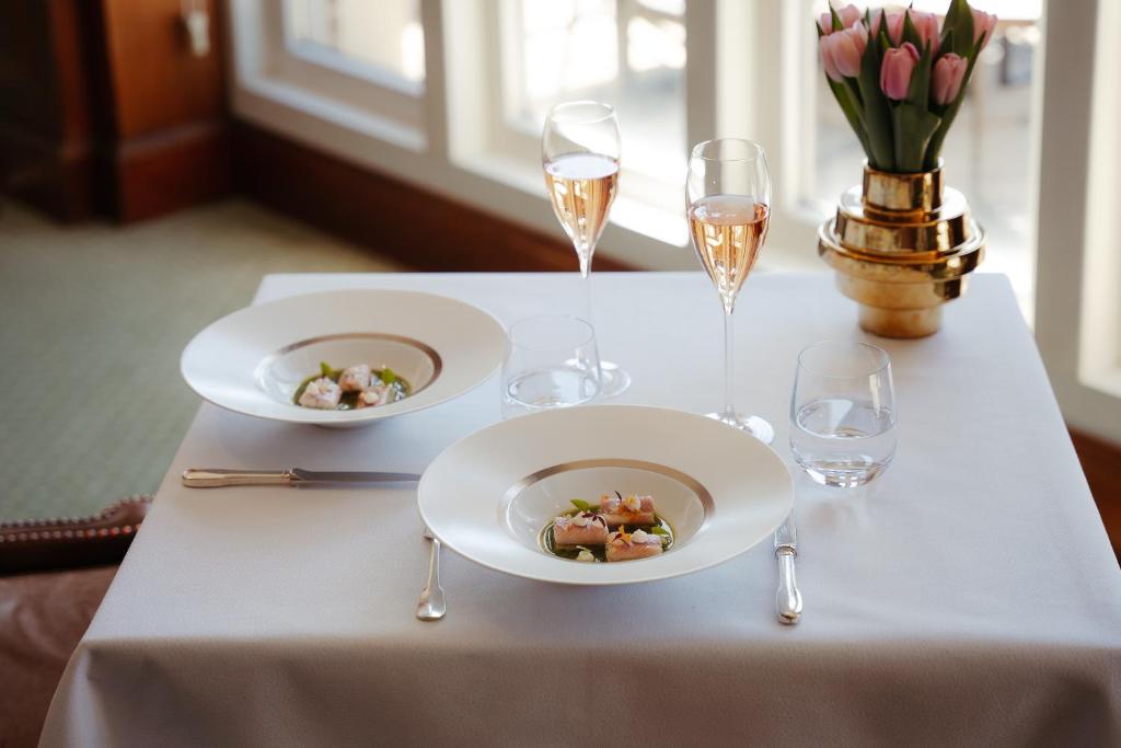 a table with two plates of food and glasses of champagne at InterContinental Amstel Amsterdam by IHG in Amsterdam