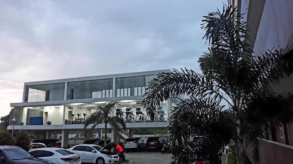 a building with cars parked in a parking lot at Lai Stay in Lapu Lapu City
