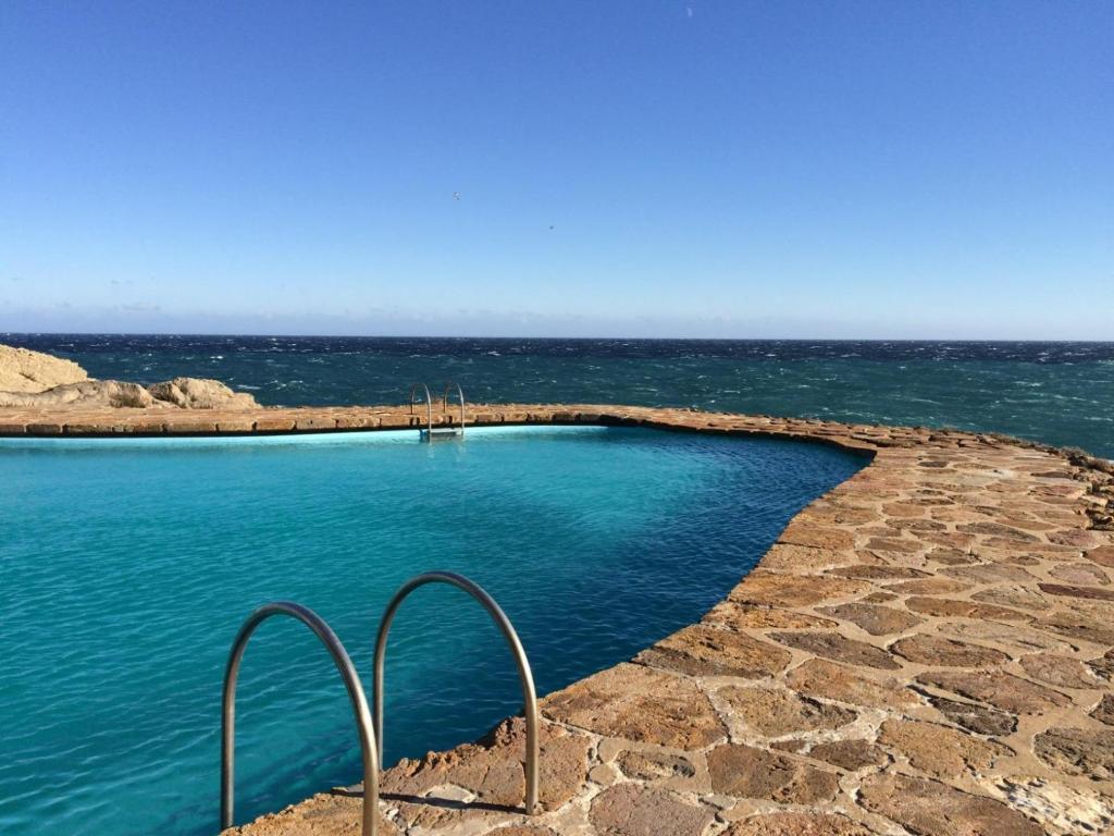 a swimming pool with the ocean in the background at El 66 de Cap Sa Sal in Begur