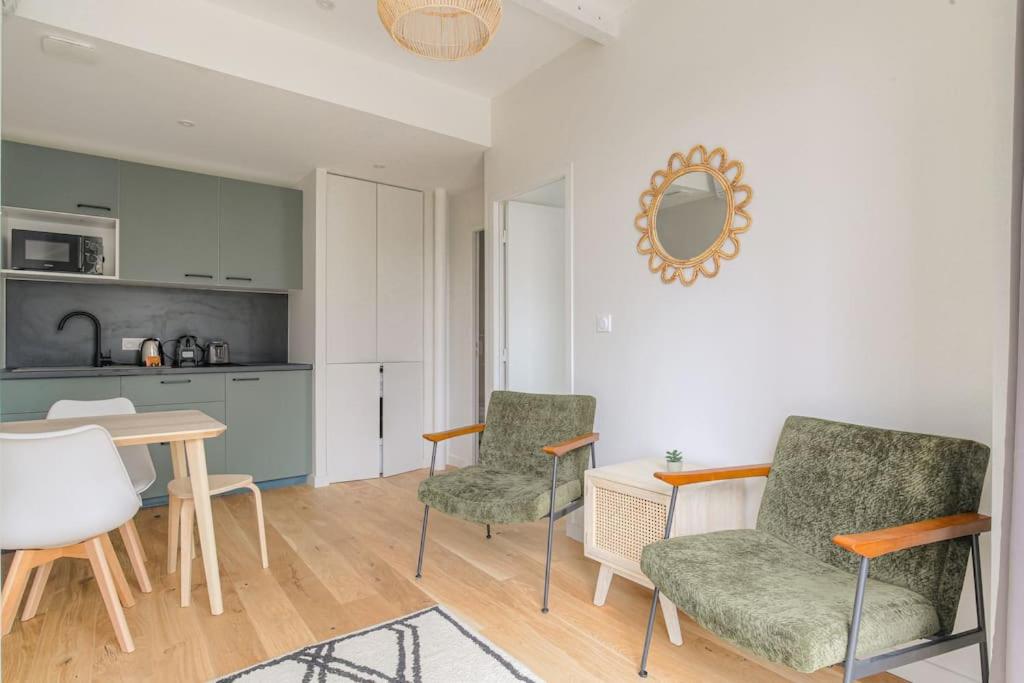 un salon avec deux chaises et une table dans l'établissement Appartement neuf, clim et parking, Caluire-Dombes, à Caluire-et-Cuire
