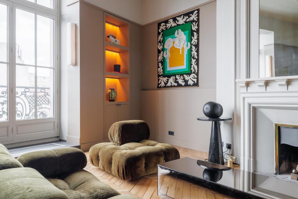 un salon avec deux chaises et une cheminée dans l'établissement Atelier Artiste, à Paris