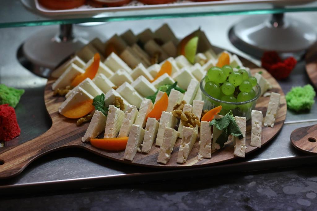 a plate of cheese and vegetables on a table at Arena Mar Hotel and SPA in Golden Sands
