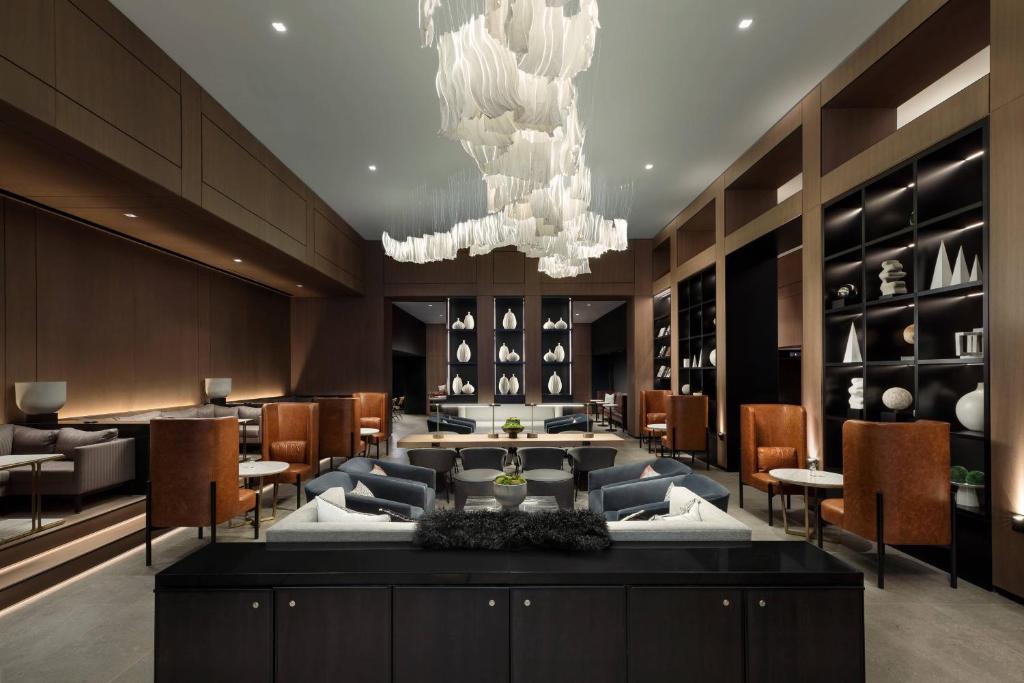 a hotel lobby with a chandelier and tables and chairs at AC Hotel by Marriott Washington DC Downtown in Washington