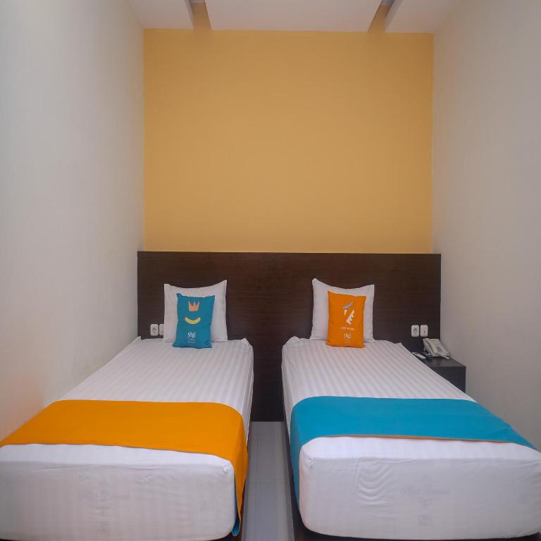 Postel nebo postele na pokoji v ubytování Sans Hotel Nagari Malioboro