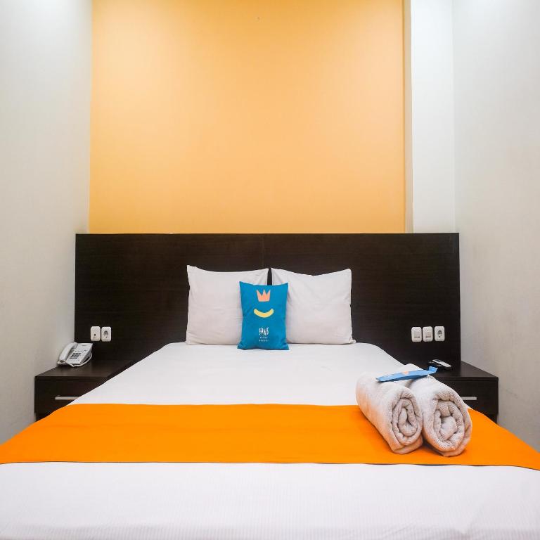 Postel nebo postele na pokoji v ubytování Sans Hotel Nagari Malioboro
