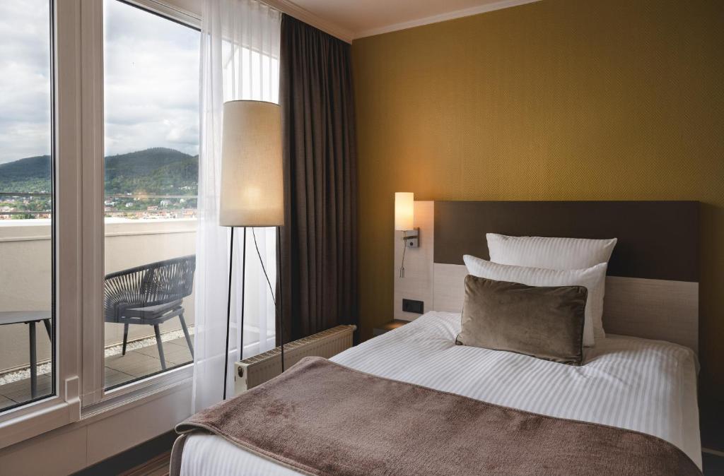 Postel nebo postele na pokoji v ubytování Leonardo Hotel Heidelberg City Center
