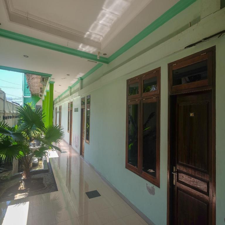 un pasillo de un edificio con una puerta y una planta en RedDoorz Plus @ Timoho, en Yogyakarta