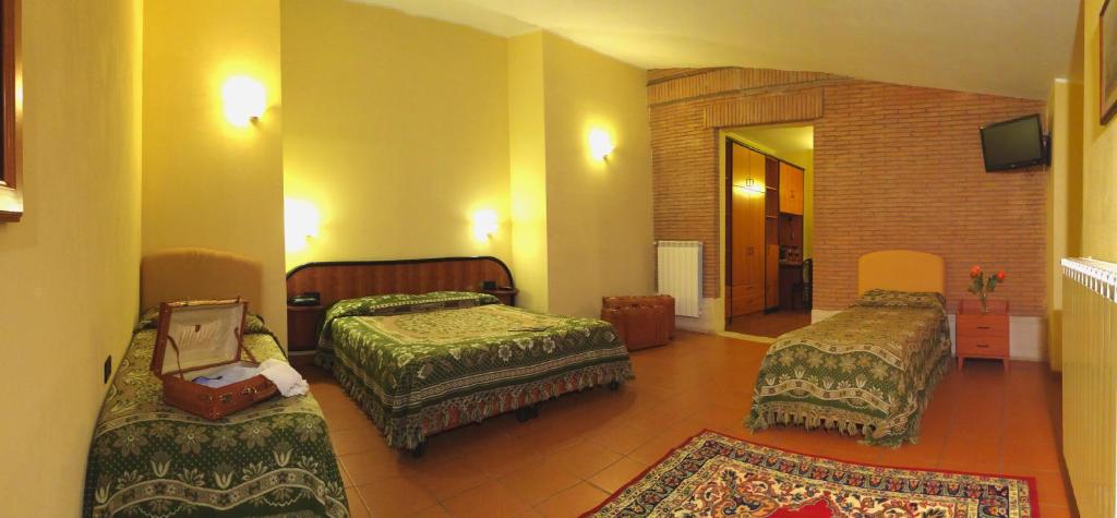 Łóżko lub łóżka w pokoju w obiekcie LH Albergo il Picchio