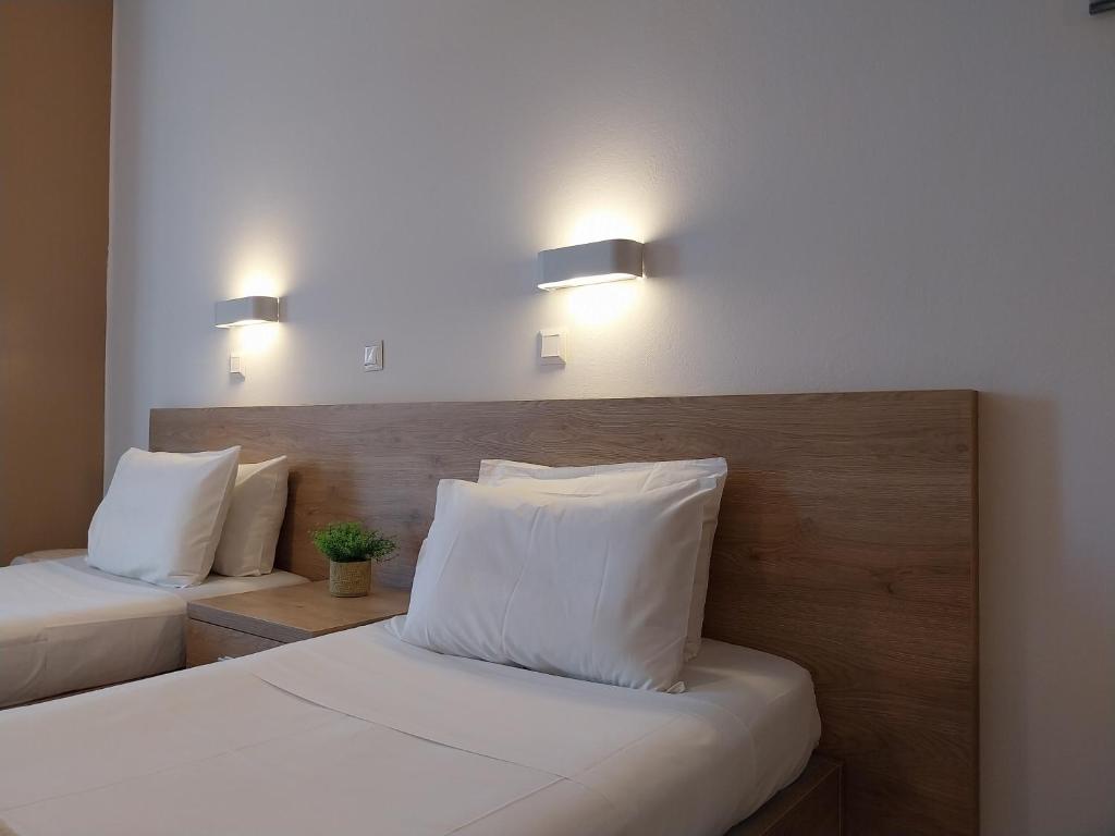 two beds with white pillows in a room at Papadatos Studios in Argostoli