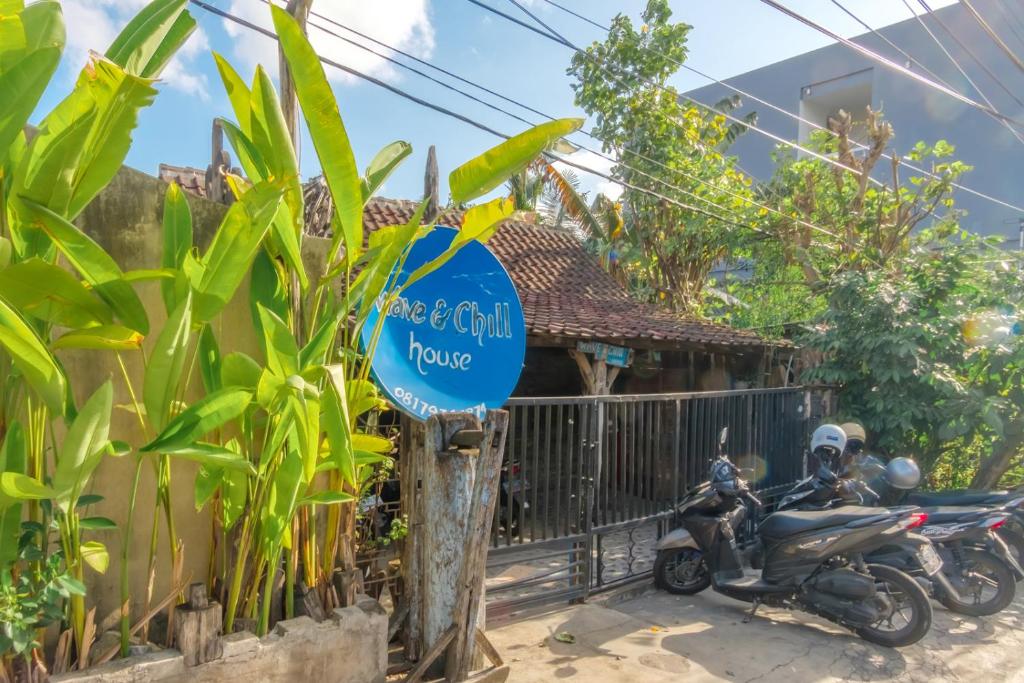 Una motocicleta estacionada junto a un cartel frente a una casa en TwoSpaces Living at Wave And Chill House, Canggu, en Canggu
