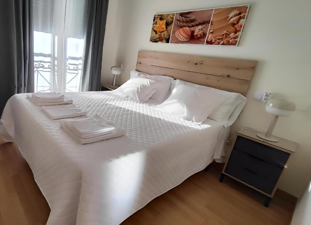 a bedroom with a white bed with white sheets and pillows at Estrella de O Vicedo in O Vicedo