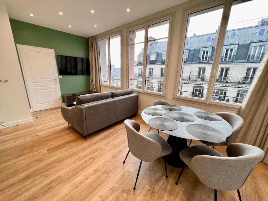 un salon avec une table, des chaises et un canapé dans l'établissement Very bright newly renovated apt with AC, à Paris