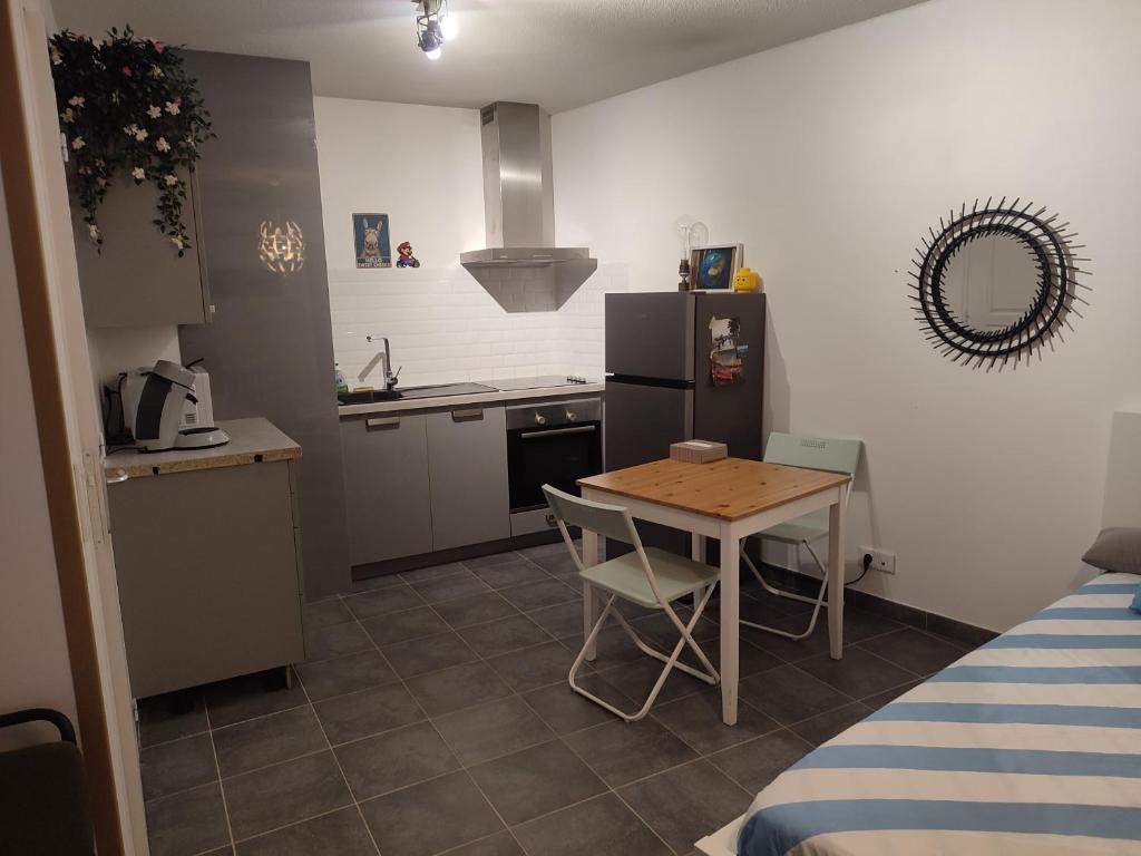 une petite cuisine avec une table et un réfrigérateur dans l'établissement SMV Studio, à Saint-Martin-du-Var