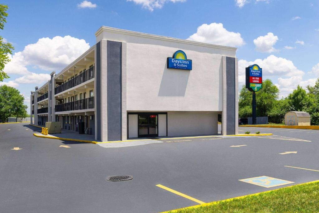 a building with a sign on the side of it at Day's Inn & Suites by Wyndham Indianapolis Airport East in Indianapolis