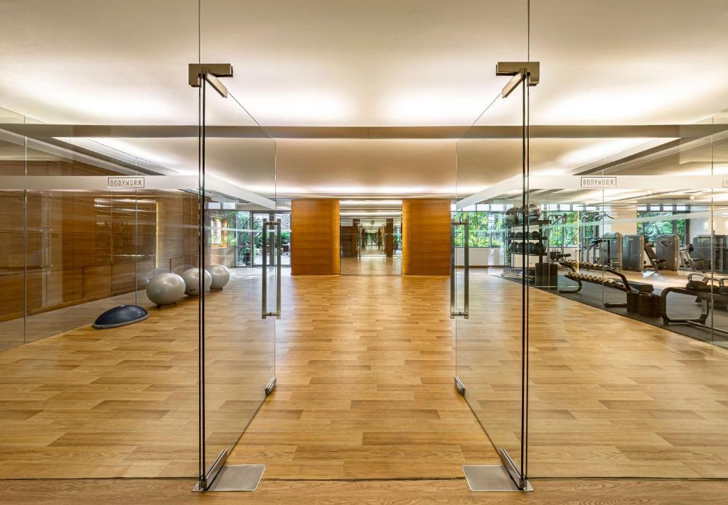 a large room with glass doors and wooden floors at Conrad Bangkok in Bangkok