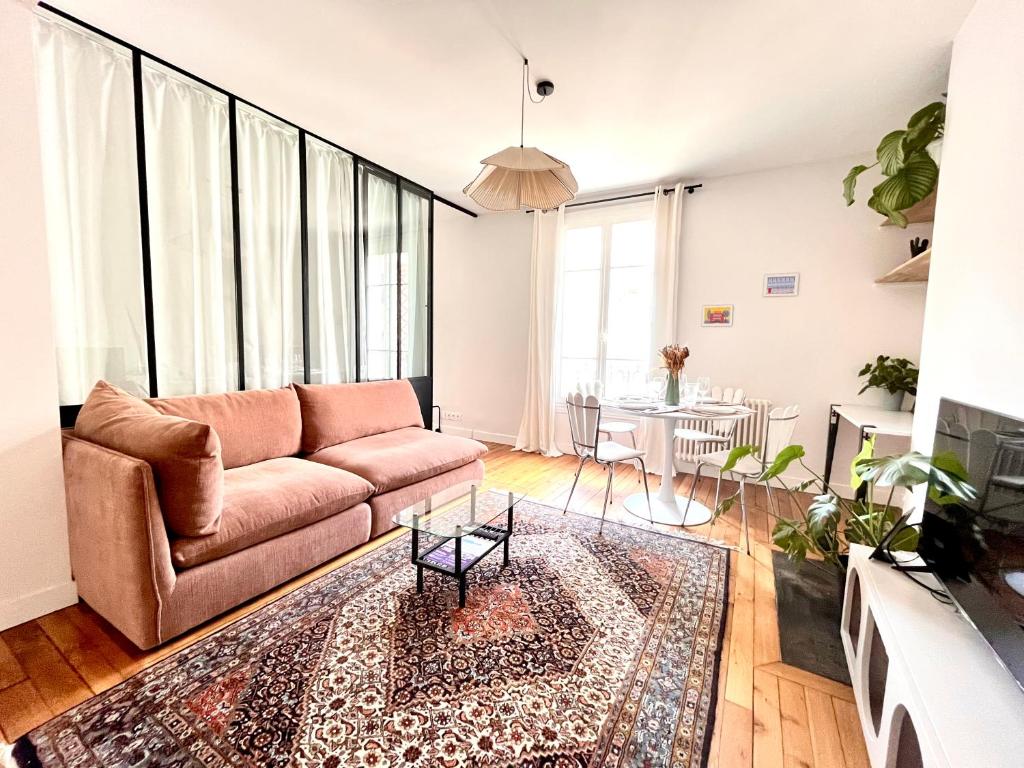 un salon avec un canapé et une table dans l'établissement Jerickais Appartement 3 pièces à Pantin, à Pantin