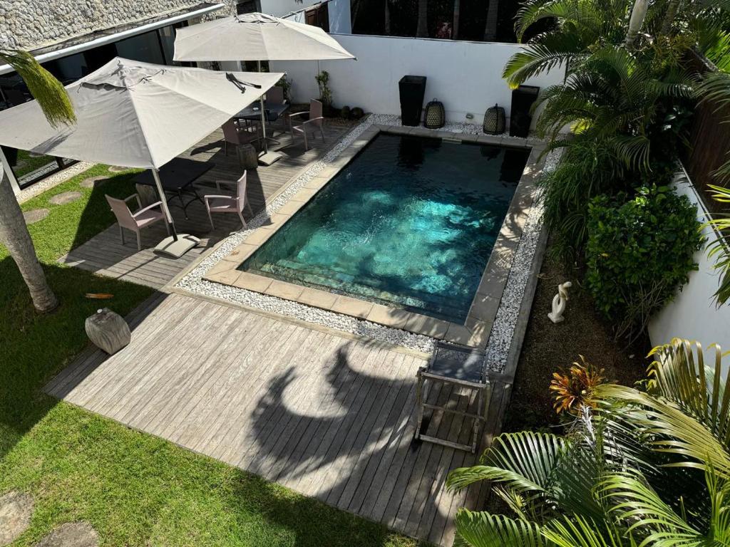 Una vista aérea de una piscina con una sombrilla. en Residence Bel été, en Trou aux Biches